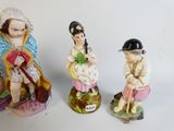 three figurines of people are shown on a white surface