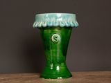 a green vase that is sitting on a table