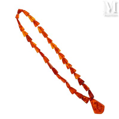 une image représentant un collier composé de perles de verre orange sur fond blanc