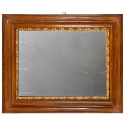 un vieux miroir à cadre en bois avec une bordure dorée