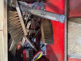 a red box with a broom and a brush inside of it