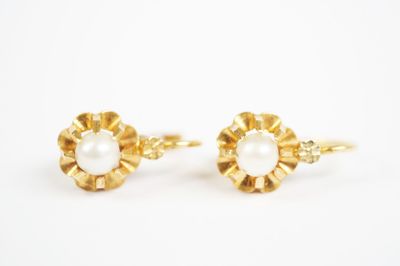 a pair of pearl and gold earrings on a white background