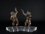 une paire de figurines en bronze représentant un garçon et une fille, posées sur un socle