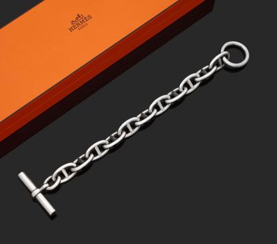 une boîte orange ornée d'une chaîne argentée, à côté d'une autre boîte orange