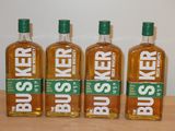 Quatre bouteilles de Busser sont alignées sur une table en bois