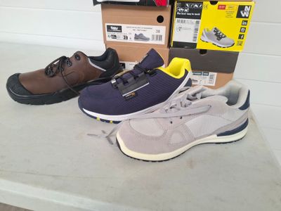 three pairs of shoes sitting on a table next to a box