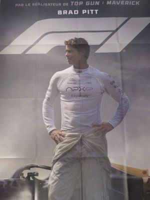 une affiche représentant un homme debout devant une voiture de course