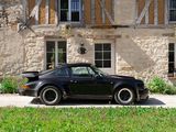 a black car parked in front of a stone building