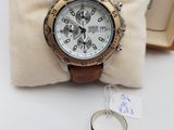la montre est posée sur un oreiller, à côté d'une bague