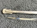 pair of silverware spoons with handles on a gray surface