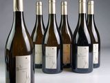 six bottles of wine are lined up in a row on a table