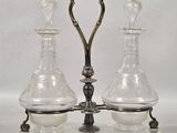 two glass vases on a metal stand with a handle