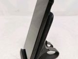 a close up of a cell phone on a stand on a white surface