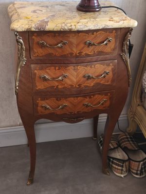 a marble top chest of drawers with a lamp on top of it