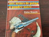 the book is sitting on a wooden table with a knife and a gun