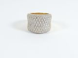 un gros plan d'une bague blanche et dorée posée sur une surface blanche