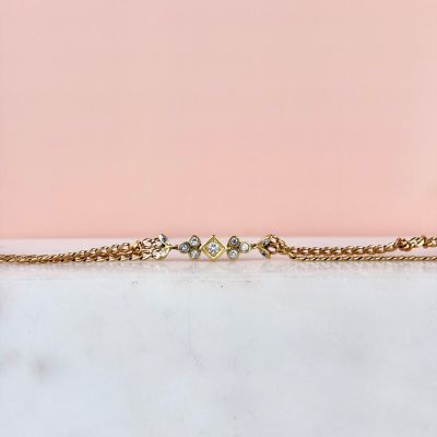 un gros plan sur un bracelet en chaîne en or orné de trois petits diamants