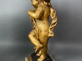 an antique bronze figurine of a cheroon holding a flower