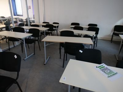 tables and chairs in a room with a lot of windows