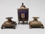 three pieces of silver and blue glass are sitting on a white surface