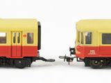 two toy trains sitting side by side on a white surface