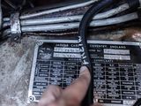 a person pointing at a wiring board on a vehicle