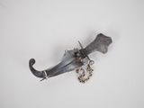 a knife with a chain attached to it on a white surface