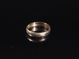 a close up of a silver ring on a black surface