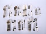 many forks and spoons laid out on a white surface