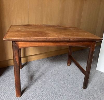 une image représentant une table en bois posée sur un sol recouvert de moquette