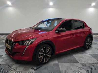 une voiture rouge garée sur un sol à damier dans un showroom