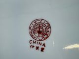 a white plate with a red and black design on it