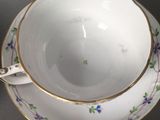 a cup and saucer on a table with a spoon
