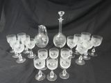 a lot of wine glasses and a decanter on a table