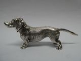une figurine antique en argent représentant un chien, sur fond blanc