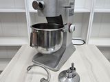 a mixer sitting on a table with a metal bowl on it