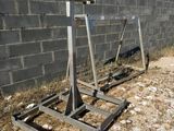 two metal stands on the ground next to a brick wall