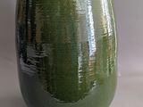 a green vase that is sitting on a table