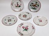 several plates with flowers and birds on them on a white surface