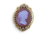 une image représentant une broche violette et dorée avec le profil d'une femme