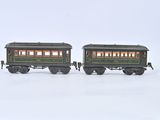 two toy trains sitting side by side on a white surface