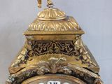 a gold clock with a bird on top of it
