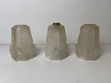 three white glass vases sitting on top of a white table