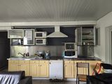 an image of a kitchen with yellow cabinets and a black couch
