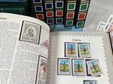 a book with stamps on it sitting next to a stack of books