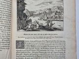 an open book with a picture of a town in the background