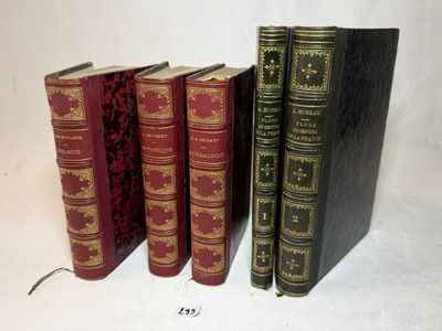 trois vieux livres sont alignés sur une surface blanche