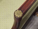 a close up of a wooden chair with a gold knob on it