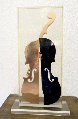 a sculpture of a violin and a violin case on a table