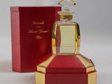 an image of a bottle of perfume sitting on top of a red box